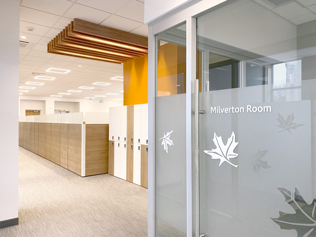 Hallway in office with signs on glass meeting rooms.